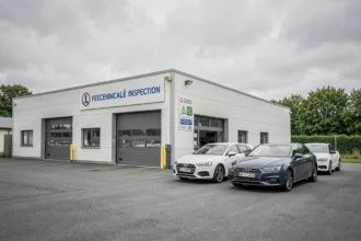 Vue extérieure d'un centre de contrôle technique en Normandie avec des voitures garées devant